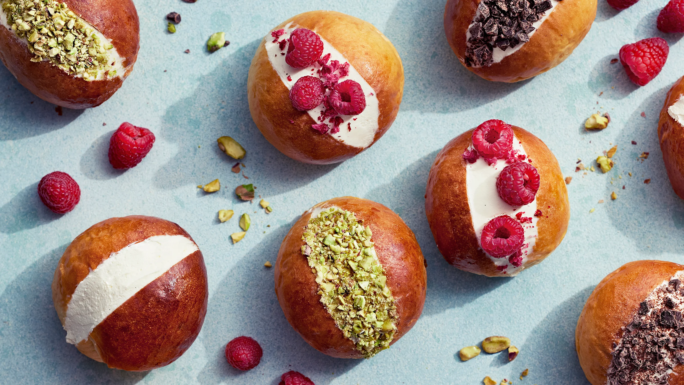 Maritozzi-pullia vadelmilla, pistaasirouheella ja suklaarouheella koristeltuna.