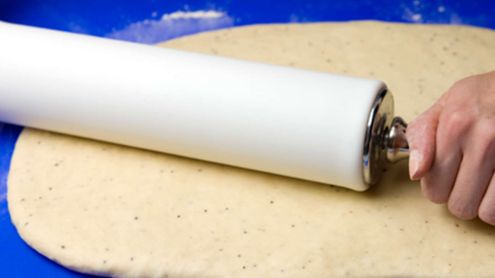 Kumoa kohonnut taikina jauhotetulle leivonta-alustalle. Vaivaa taikinasta ilmakuplat pois. Kauli taikina jauhojen avulla laajemmaksi, suorakaiteen muotoiseksi levyksi (n. 30 x 40 cm).