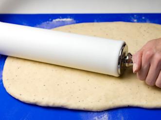 Kumoa kohonnut taikina jauhotetulle leivonta-alustalle. Vaivaa taikinasta ilmakuplat pois. Kauli taikina jauhojen avulla laajemmaksi, suorakaiteen muotoiseksi levyksi (n. 30 x 40 cm).