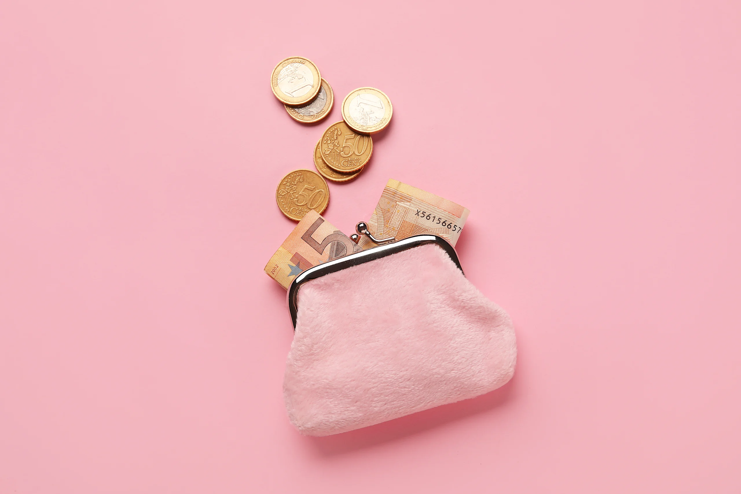 Seteleitä ja kolikoita vaaleanpunaisessa lompakossa