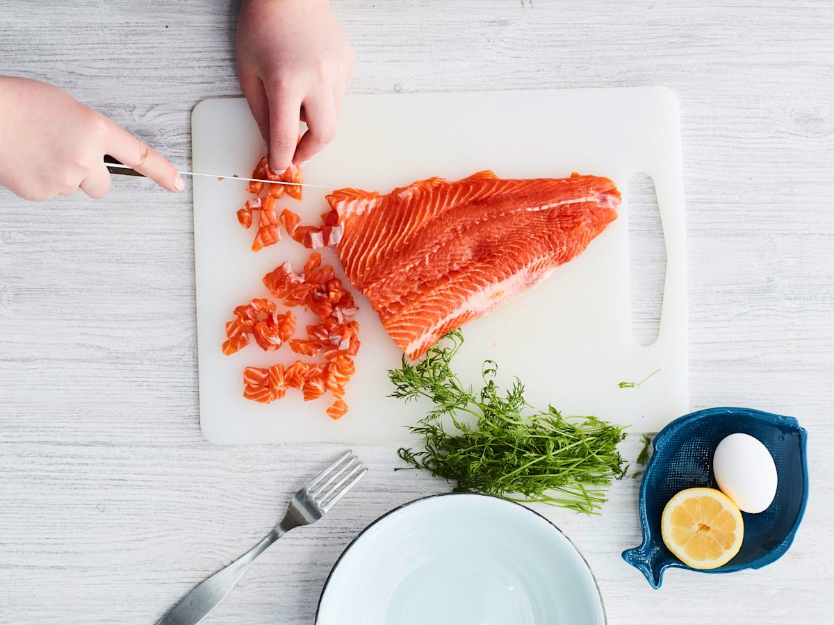 Ota toiseen käteen iso veitsi. Laita se kapeassa päässä lihan ja nahan väliin. Työnnä leveään päähän nahan reunaa pitkin niin, että nahka leikkautuu pois. Leikkaa lohifilee pieniksi kuutioiksi.