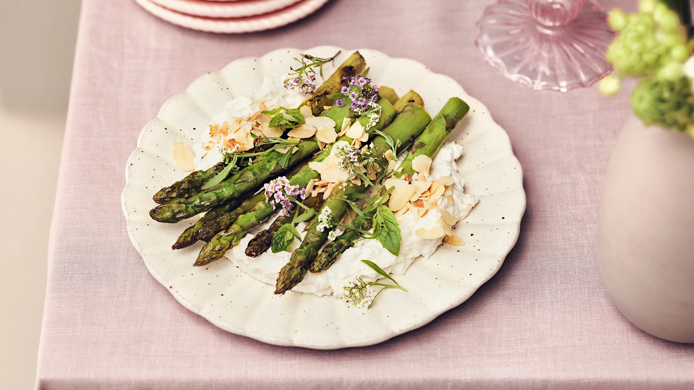 Paistetut tankoparsat vegaanisen juustovaahdon päälle aseteltuna ja mantelilastuilla koristeltuna.
