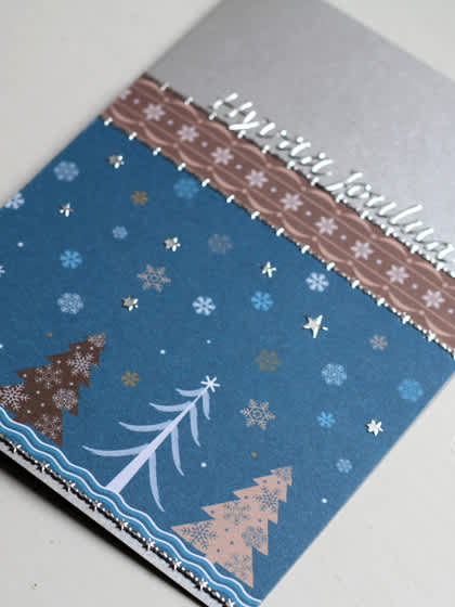**Talvinen metsä**:Sommittele korttipohjalle kartonkeja, koristepapereita ja tarroja.
