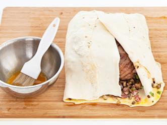 Kääri taikina fileen ympärille niin, että se peittyy. Aseta paketti saumapuoli alaspäin ja nosta uunipellille. Voitele pinta munalla. Paista 200-asteisessa uunissa, kunnes sisälämpötila on noin 60 astetta. Anna fileen levätä hetki ennen leikkaamista.