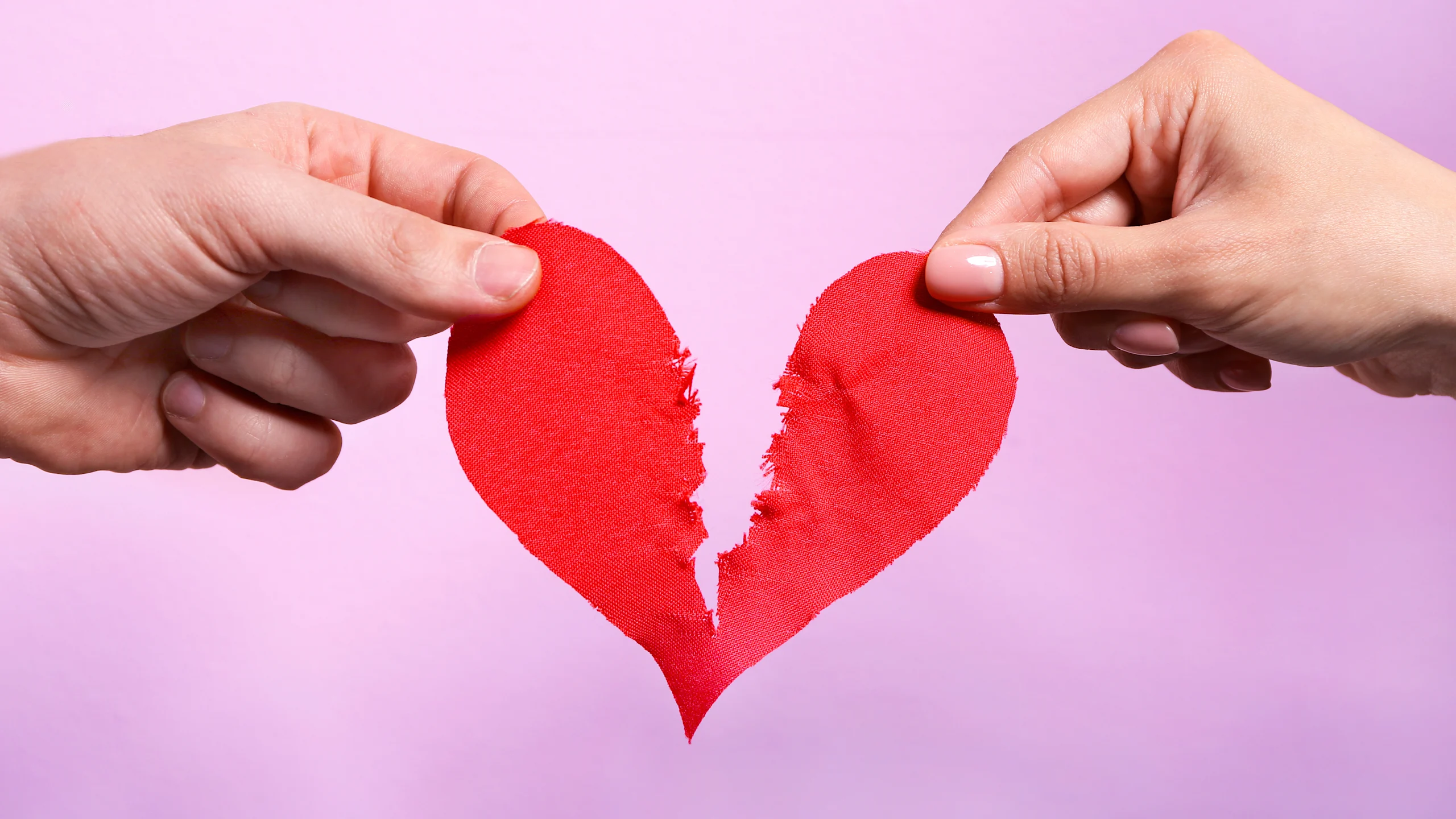 Kädet repivät kankaista sydäntä kahtia, tausta liila.