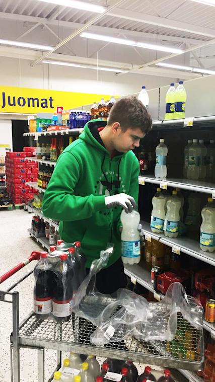 Oskari Laine hyllyttää juomia Ahtialan S-marketissa.