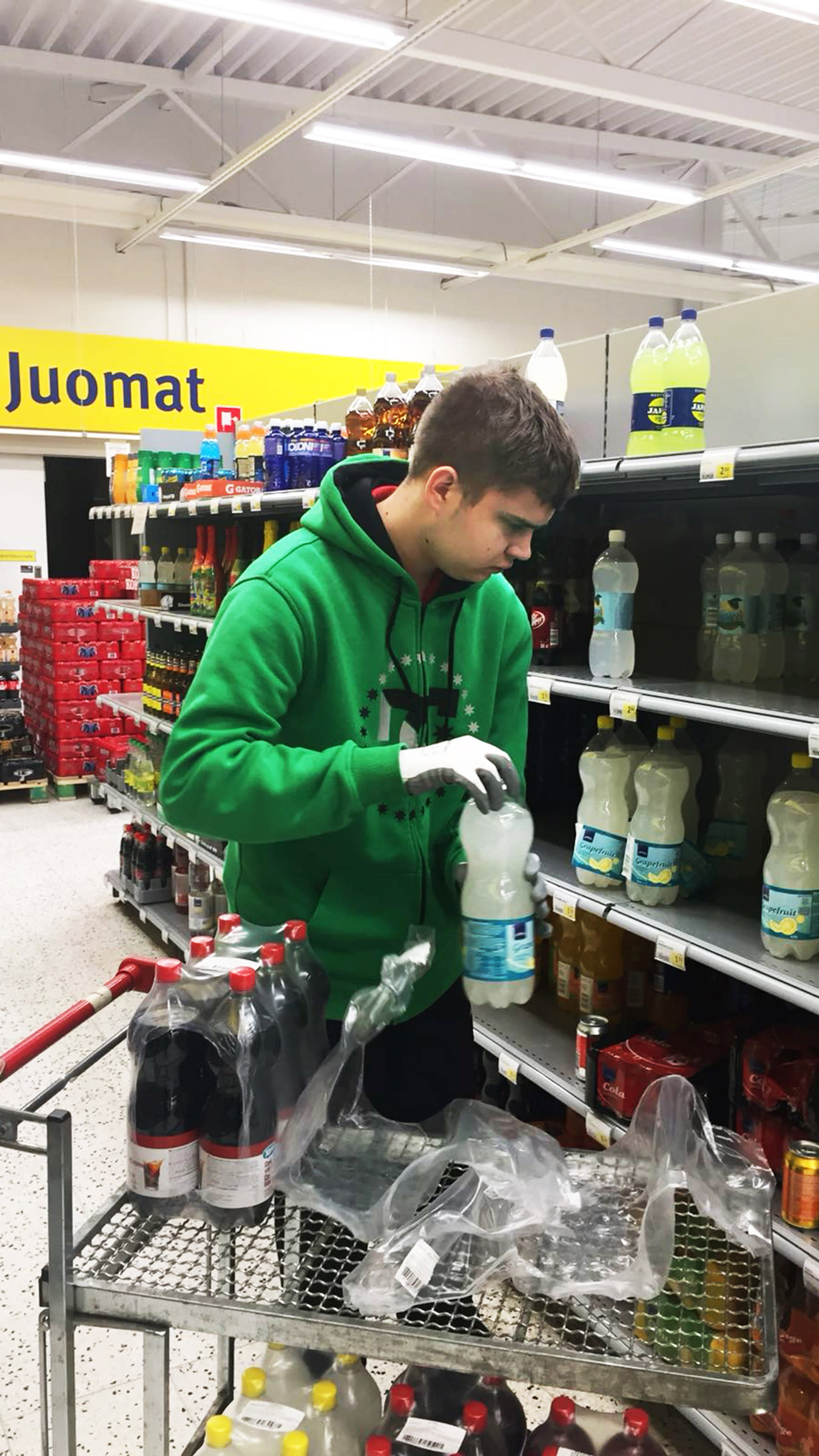 Oskari Laine hyllyttää juomia Ahtialan S-marketissa.