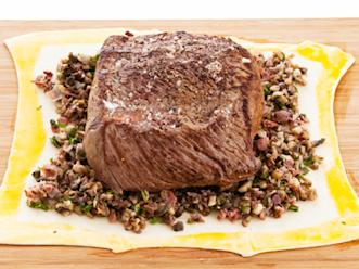 Levitä taikinalevyn keskelle sieniseosta ja nosta päälle filee. Voitele taikinan reunat munalla.