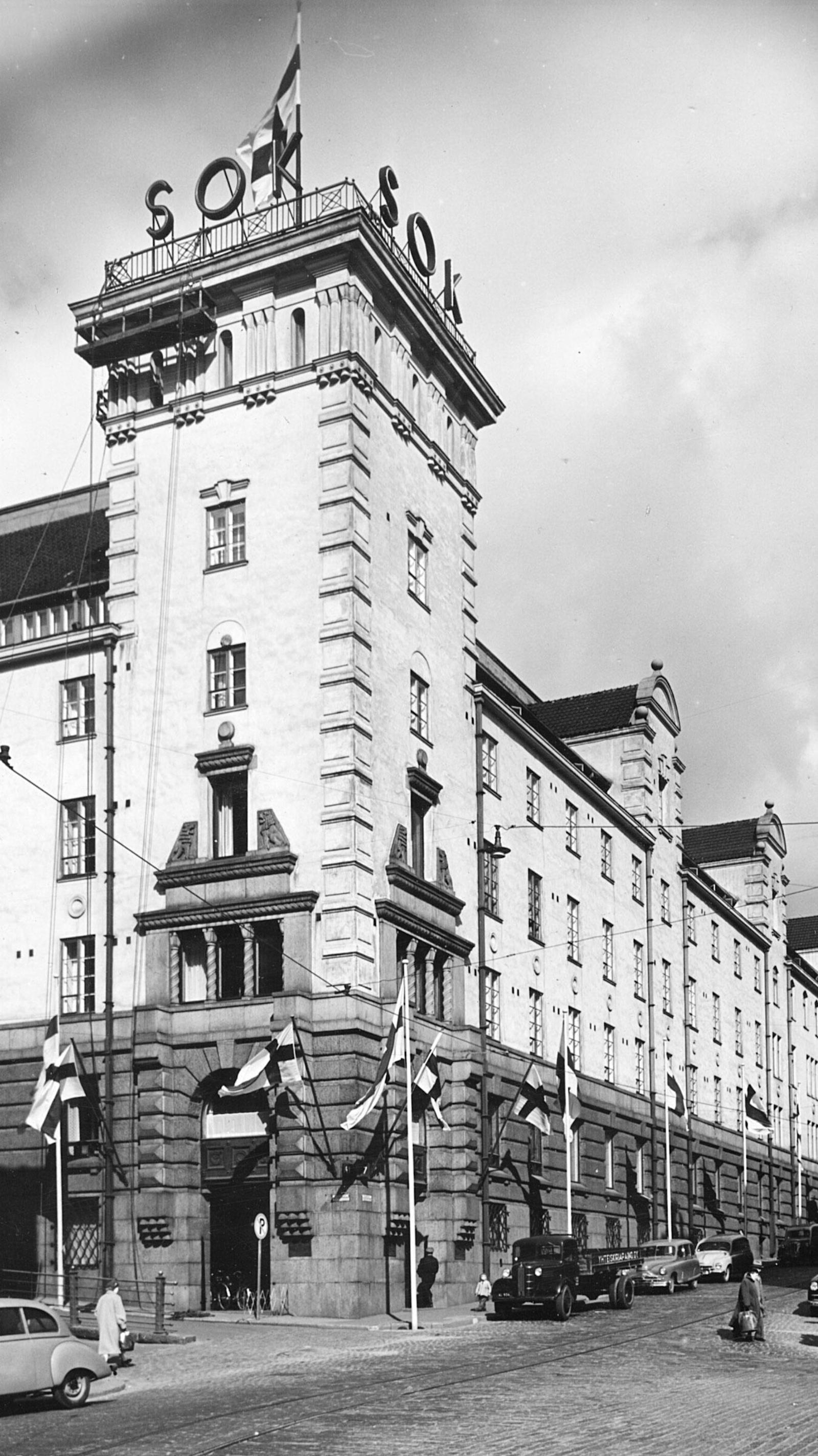 Suomen liput liehuvat saloissa juhlistamassa SOK:n pääkonttorin 50-vuotisjuhlia. 