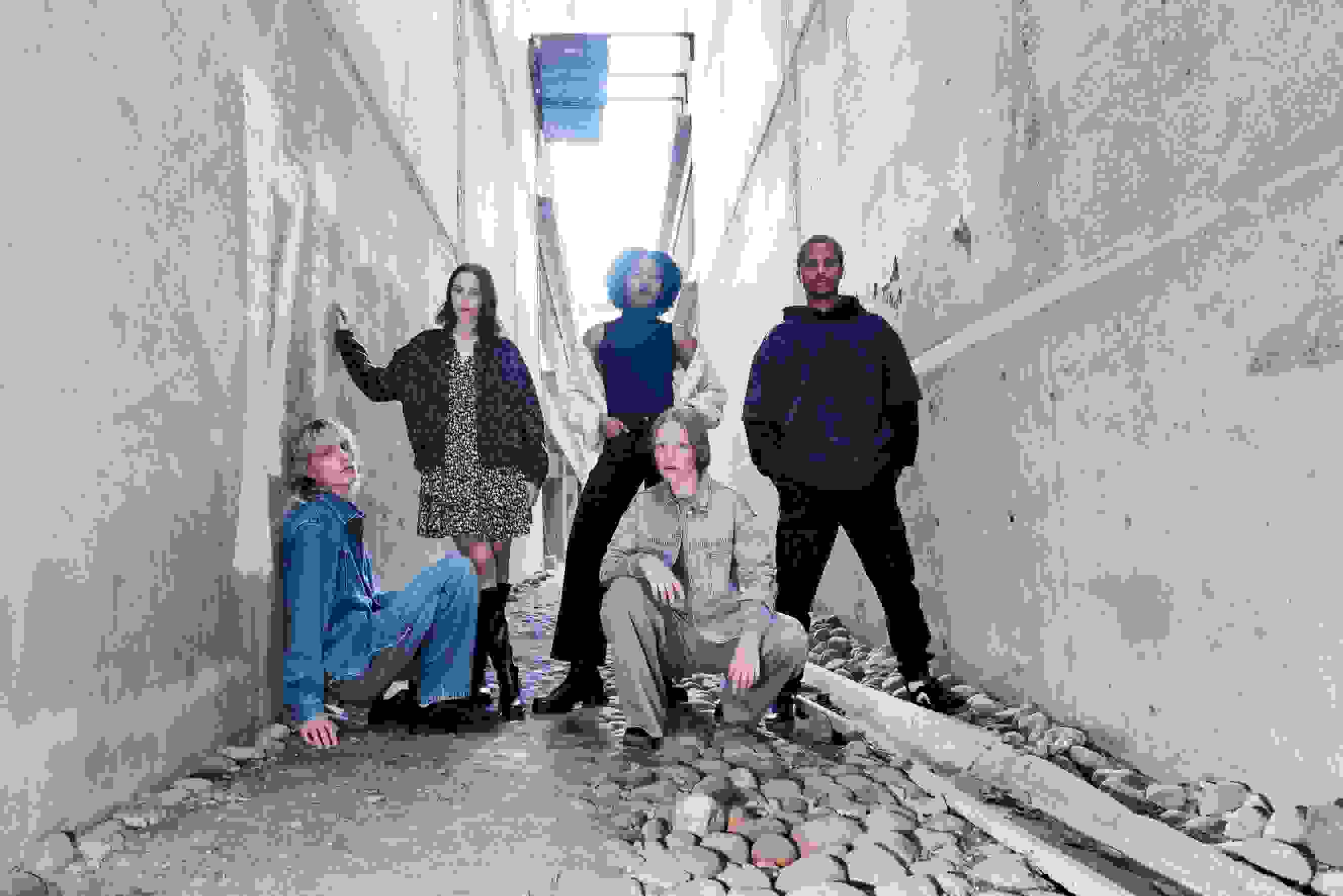 Nuoria aikuisia WKLY.-vaatteissa urbaanissa ympäristössä