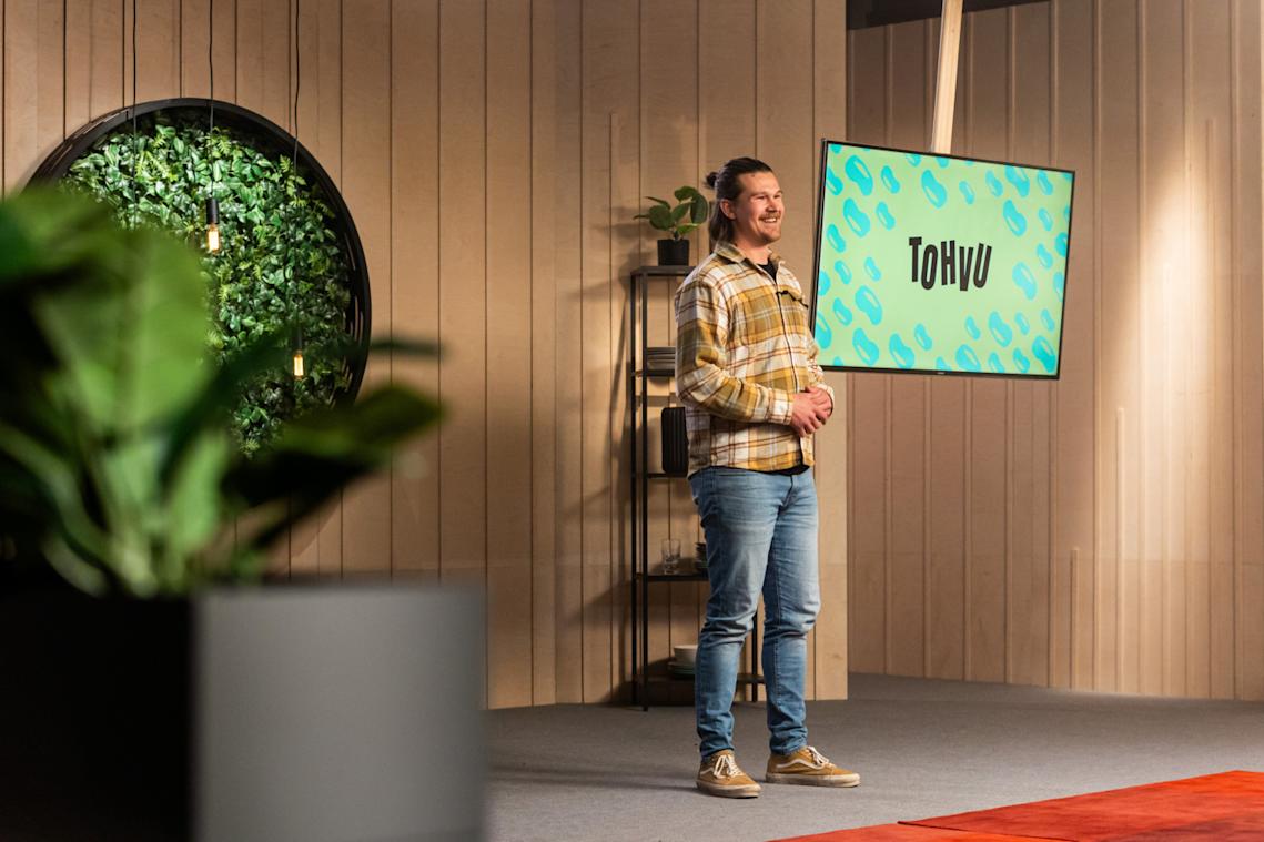 Eetu Patronen seisoo ison näytön edessä. Näytöllä lukee sana Tohvu.
