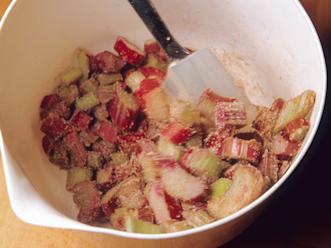 Sekoita perunajauhot, sokeri ja kaneli keskenään. Kääntele seos raparperipalojen joukkoon. Levitä seos pohjan päälle.