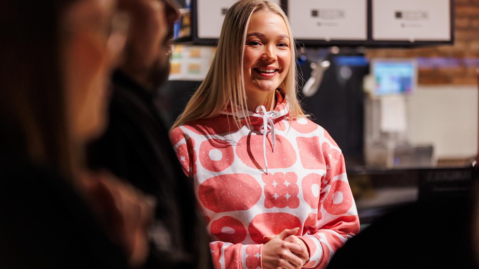 Iita hymyilee. Kuvattu myymälässä.