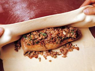 Painele fileen pinnalle sienitäytettä ja kääri taikina fileen ympärille niin, että se kokonaan peittyy. Aseta paketti saumapuoli alaspäin ja nosta uunivuokaan. Voitele fileepaketin pinta vatkatulla munalla ja pistele haarukalla.Paista 200 asteessa uuni...