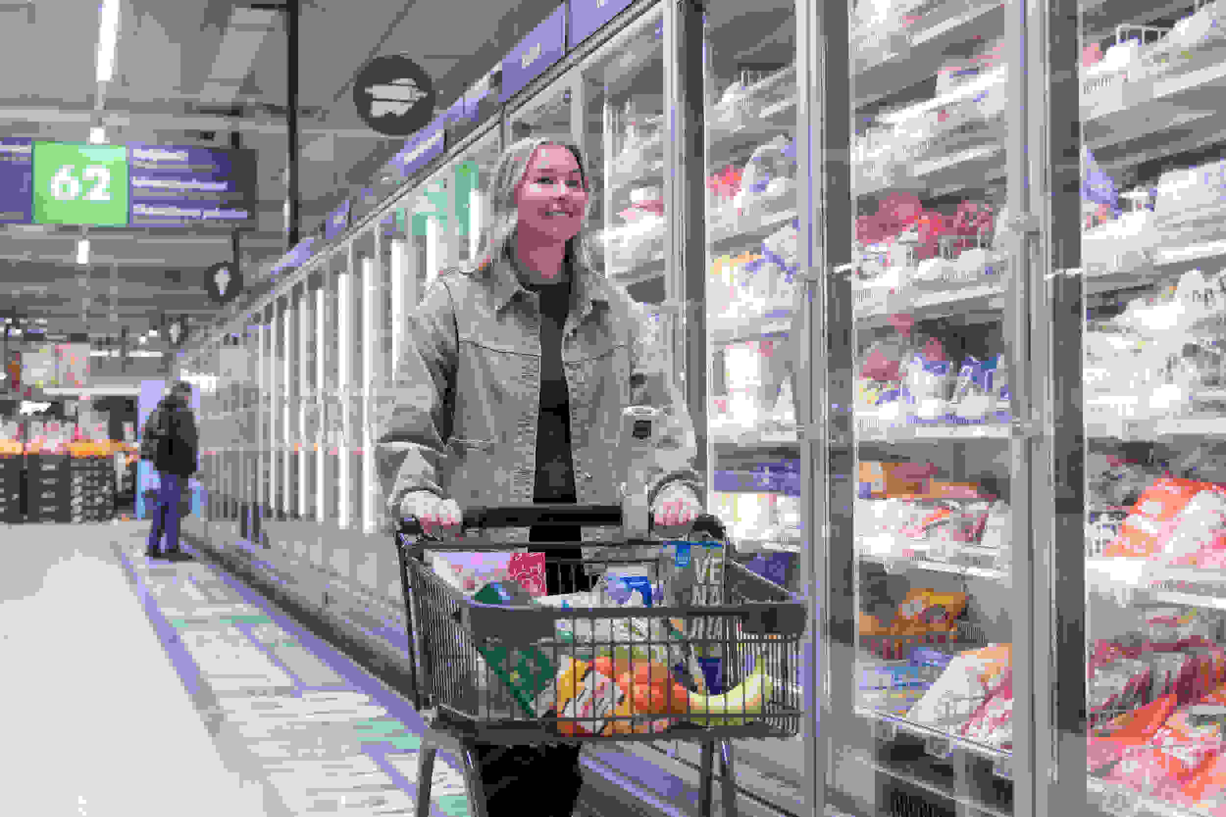 Nainen ostoskärryjen kanssa Prismassa