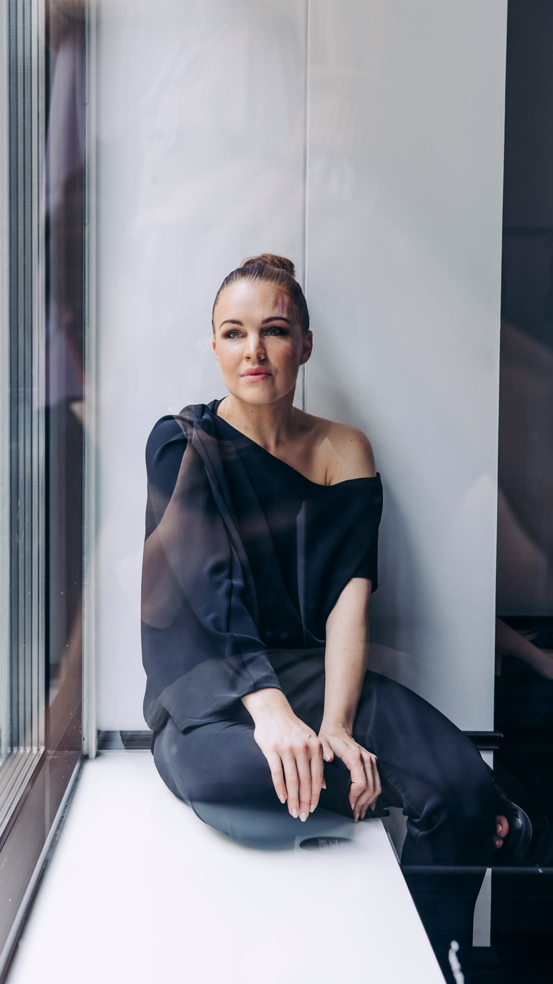 Katri Niskanen istumassa ikkunalaudalla.