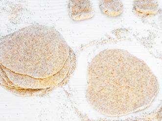 Kauli taikinapalat jauhoja apuna käyttäen pyöreiksi kiekoiksi. Kokoa pinoon, ripottele väliin jauhoja ja peitä kelmulla.