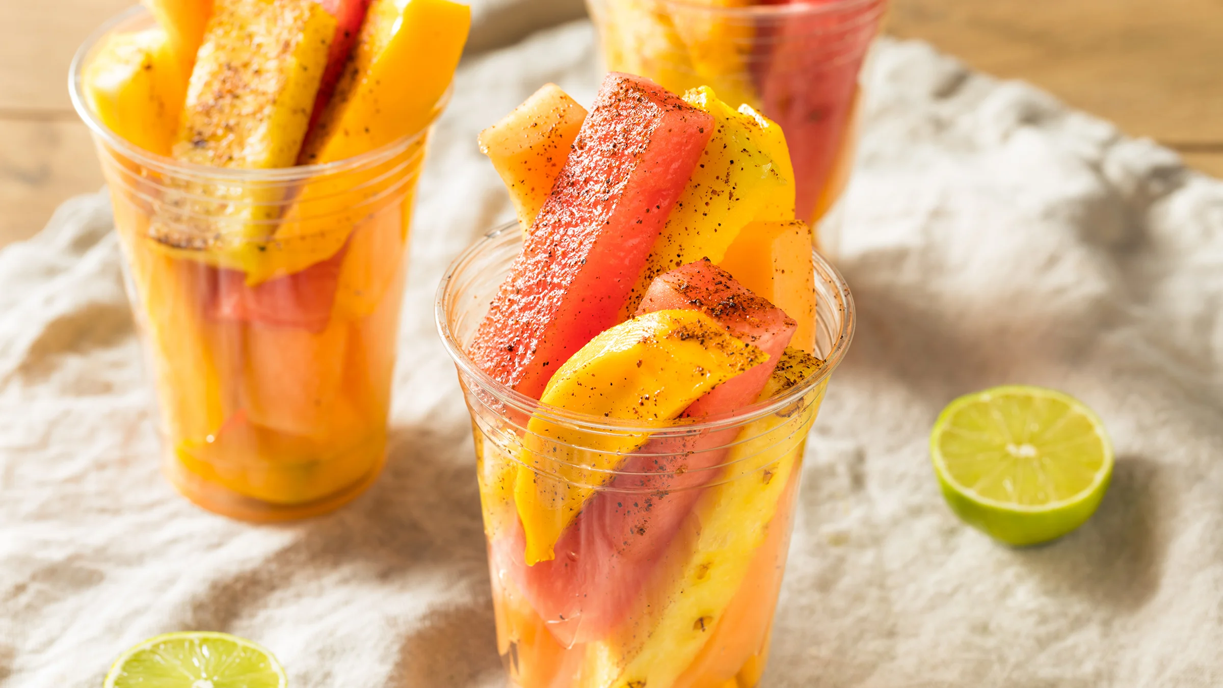 Viipaloitua mangoa ja vesimelonia mukissa. Tajín-mausteseosta ripoteltu pinnalle.