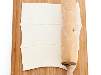 Lado sulaneet taikinalevyt vieri viereen hieman lomittain ja kauli yhteen isoksi levyksi.