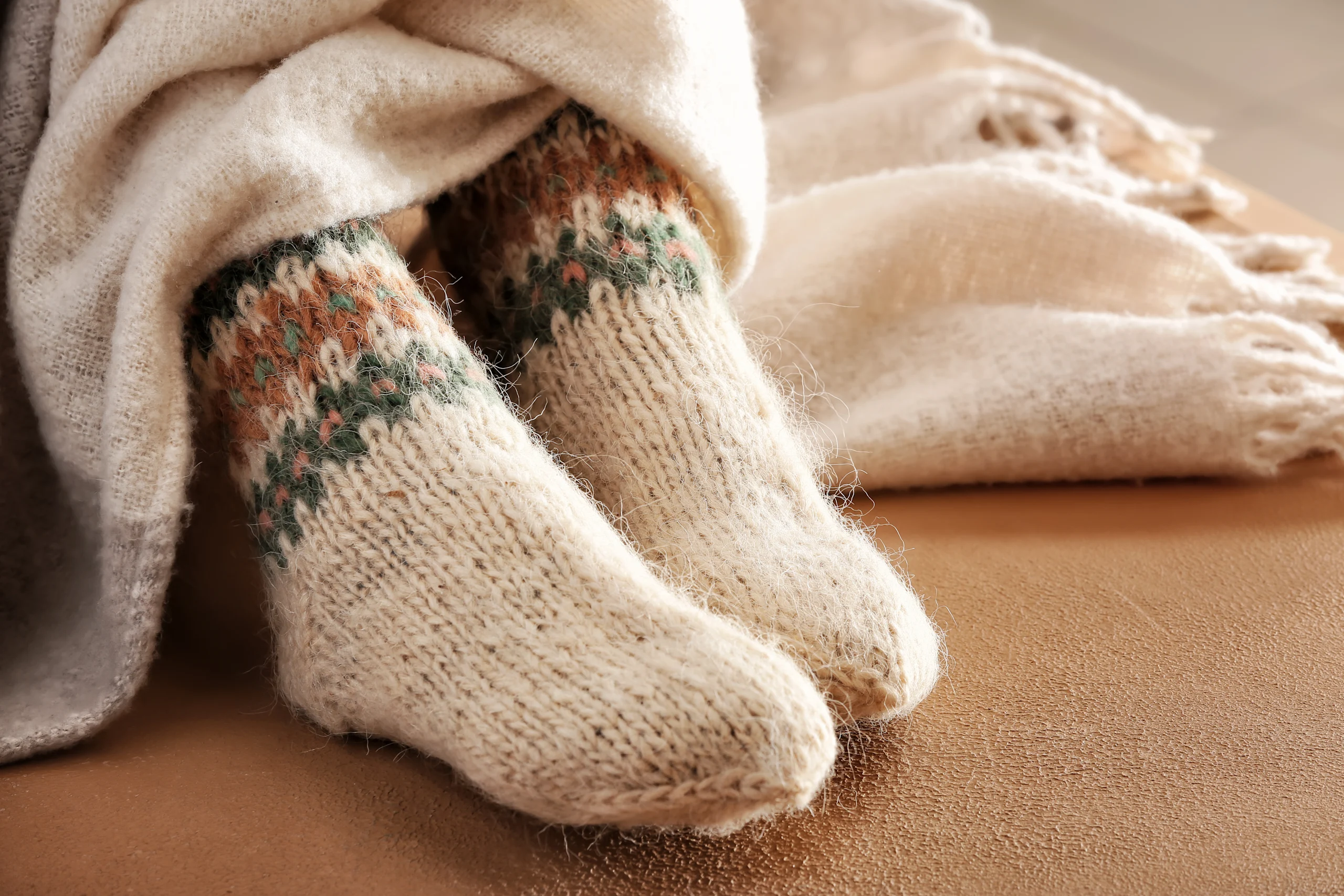 Jalassa olevat vaaleat villasukat