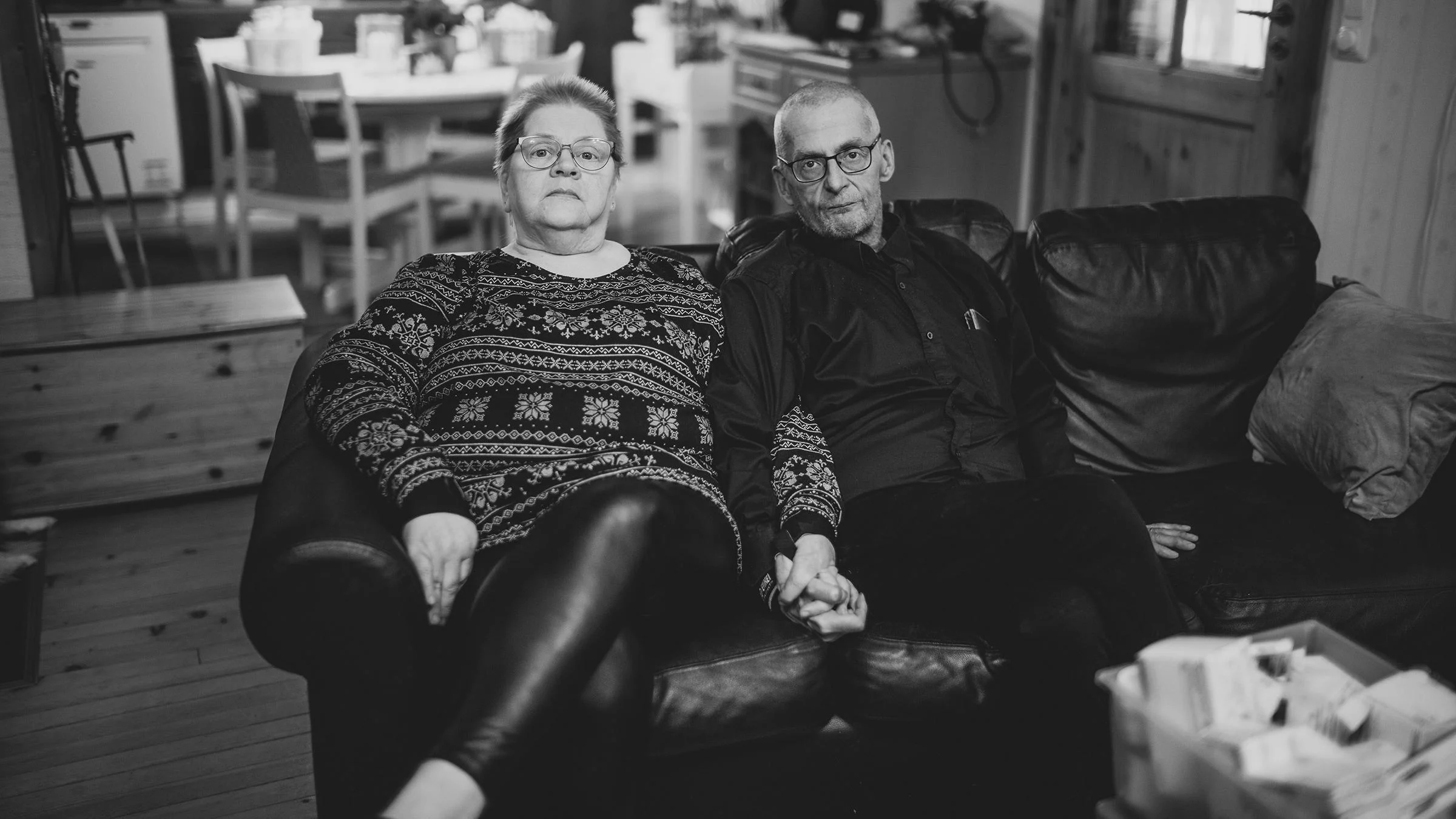 Arja Marjatsalo-Kyllästinen ja Mika Kyllästinen istuvat sohvalla käsi kädessä.