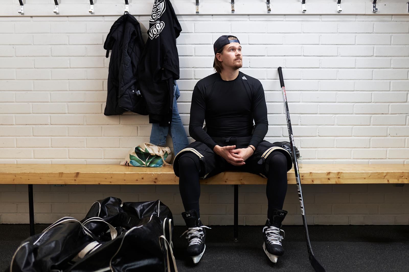 Eetu Patronen istuu jäähallin pukuhuoneessa kiekkovarusteissa