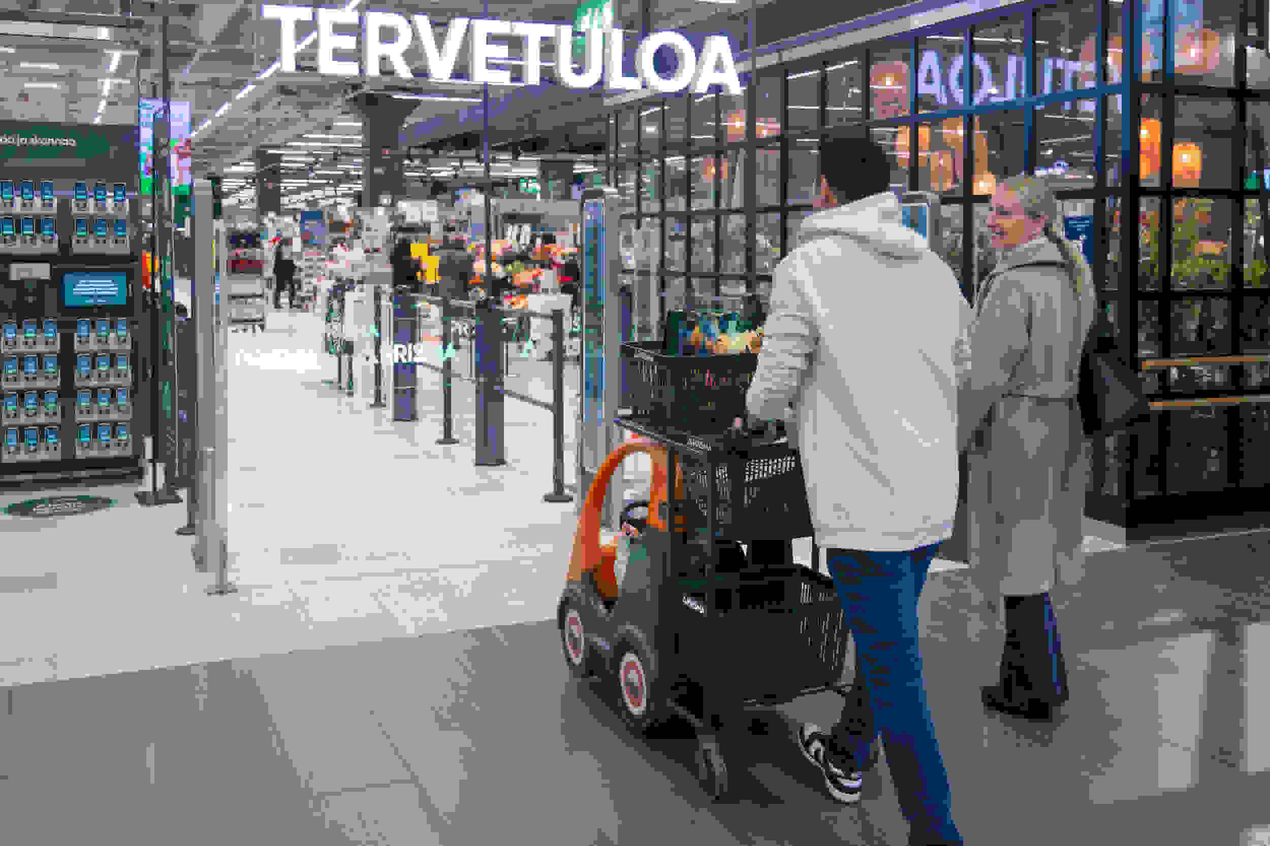 Kerää ja skannaa -teline ja perhe menossa Prismaan