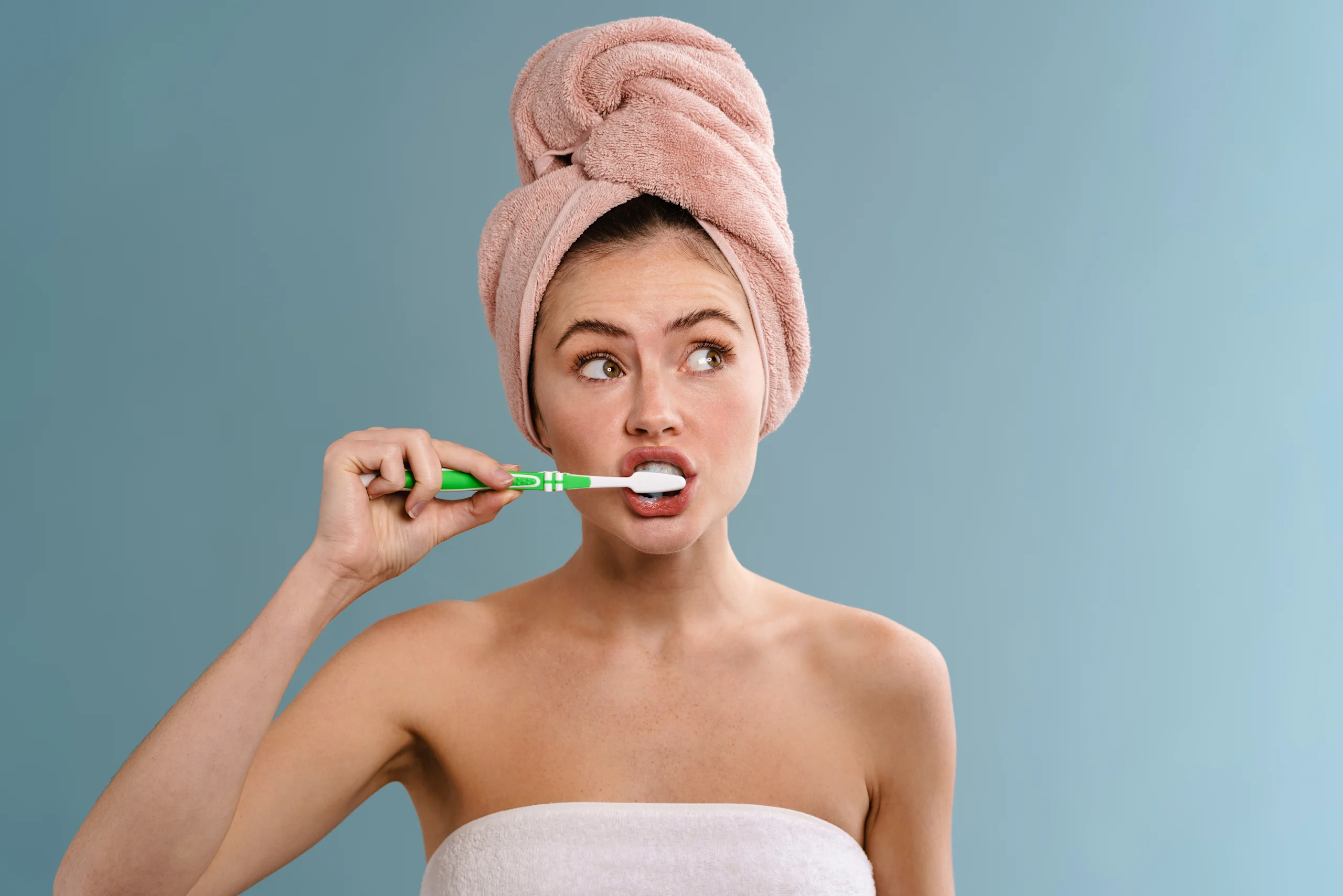 Nainen puhdistaa hampaitaan hammasharjalla