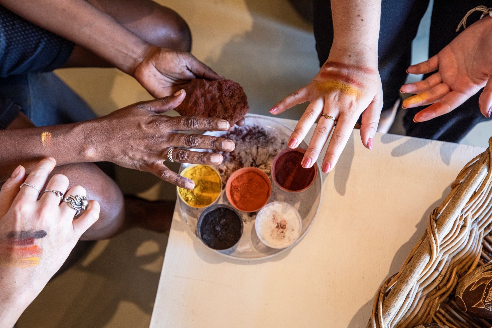 Aboriginal artists painting hands with ochre at Waringarri Aboriginal Arts, Western Australia © Tourism Australia