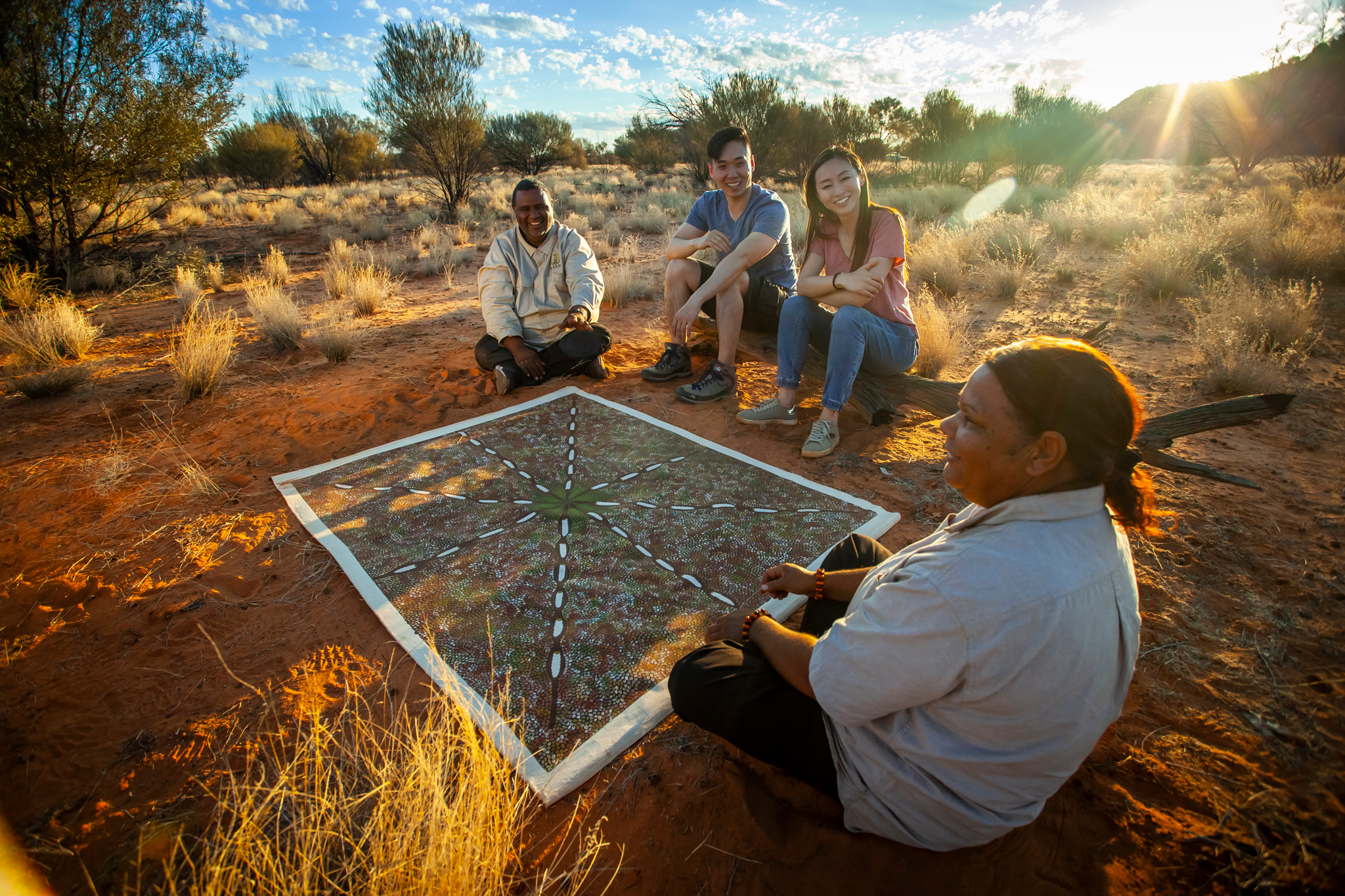 Guides sitting with couple in the outback on a Karrke Aboriginal Cultural Experience & Tours experience, NT © Tourism Australia 