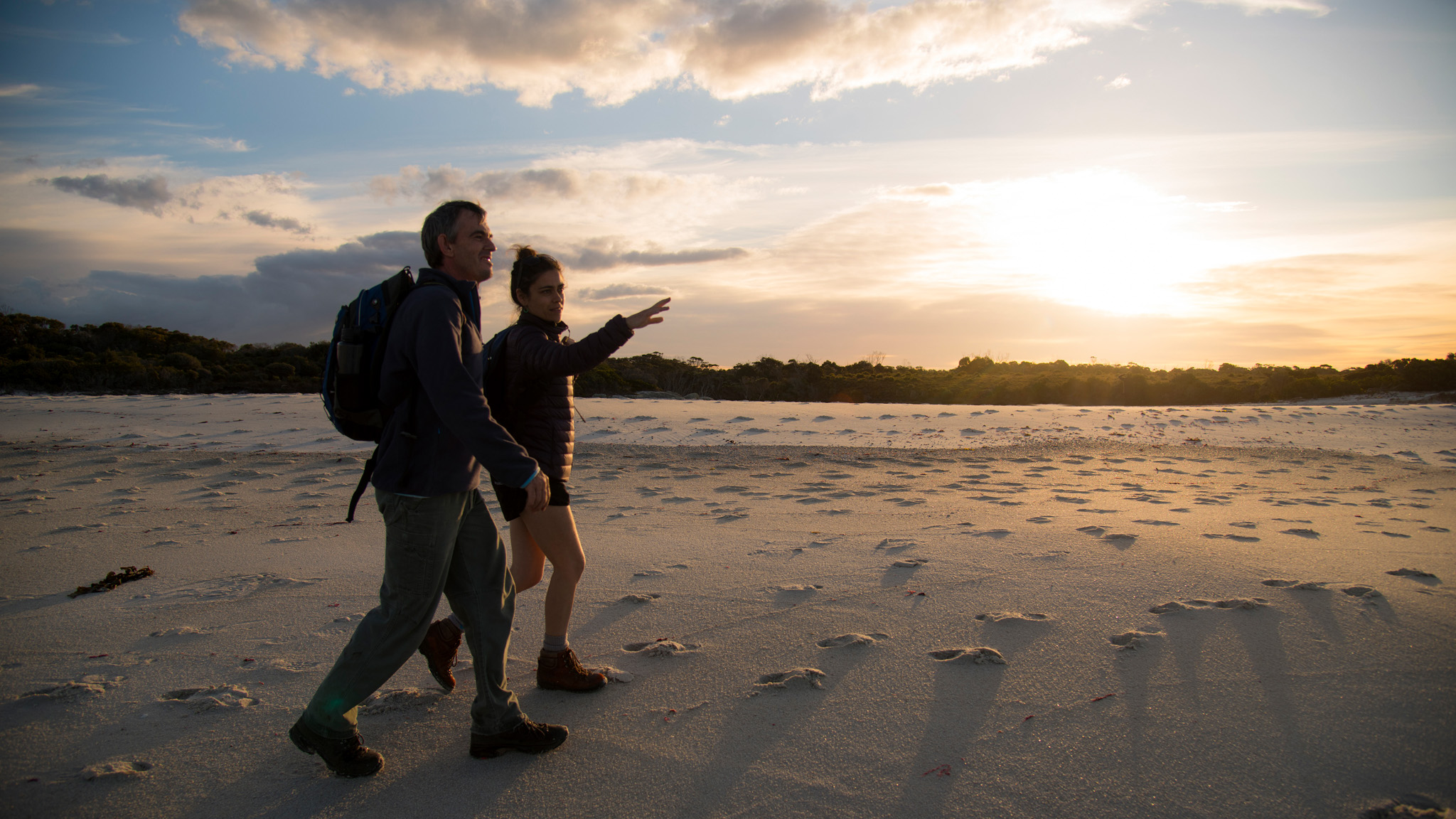 Two people walking on a Bay of Fires beach during the wukalina Walk, TAS © The Wukalina Walk 