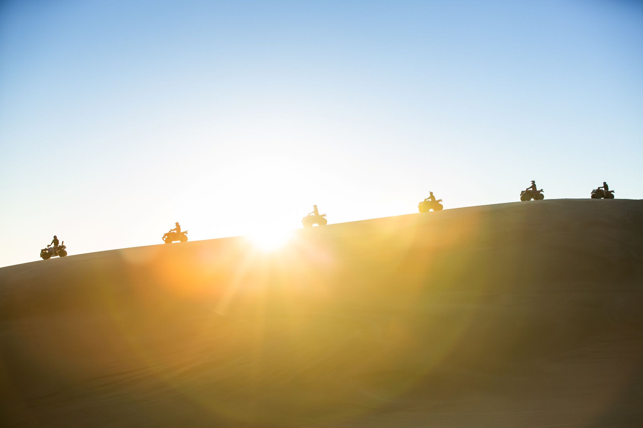 Exploring the largest moving sand dunes in the Southern Hemisphere on quad bikes with Sand Dune Adventures, New South Wales © Tourism Australia
