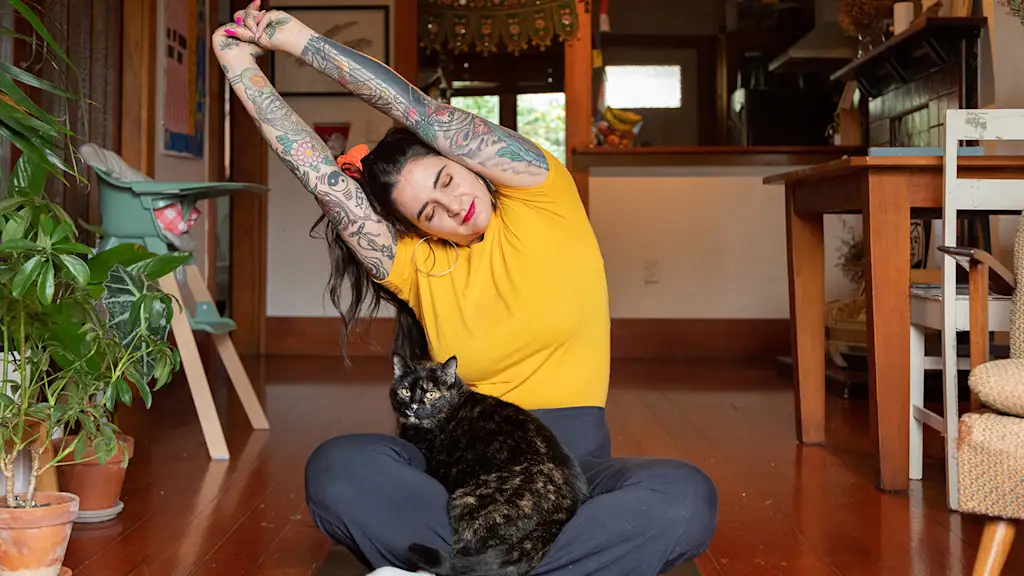 cat on the lap of a woman stretching