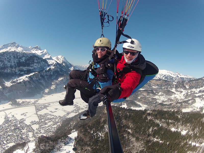 man-and-woman-taking-selfie-while-paragliding-during-daytime