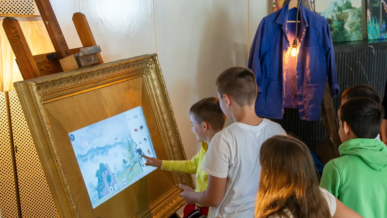 Children create a landscape together on a screen. 