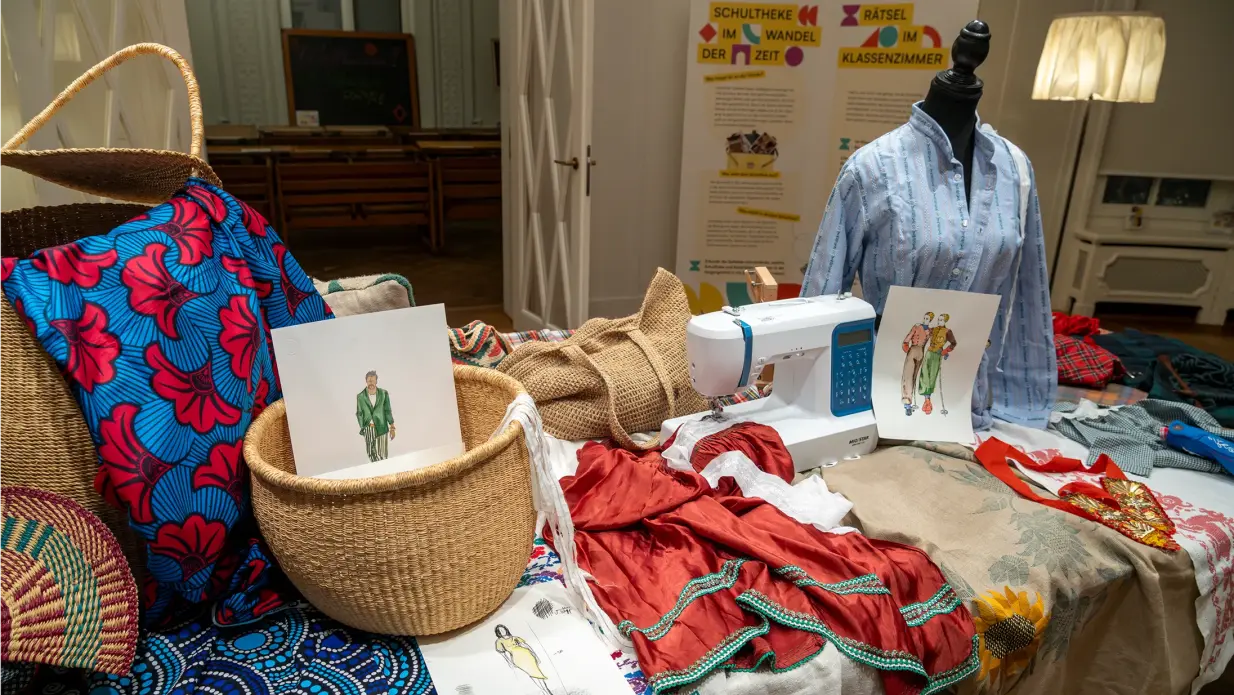 A table decorated with various fabrics and textiles from Ghana and Switzerland.