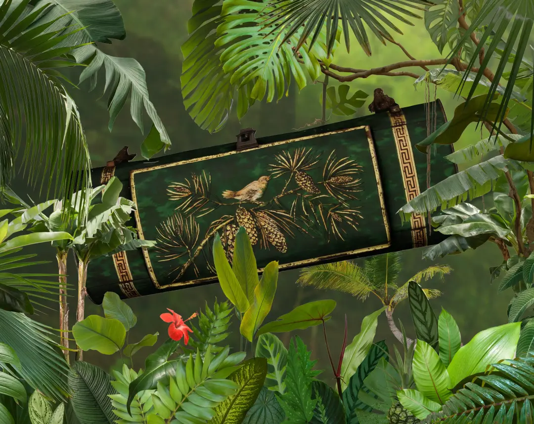A green botanical box with golden decorations showing a bird on a pine branch.