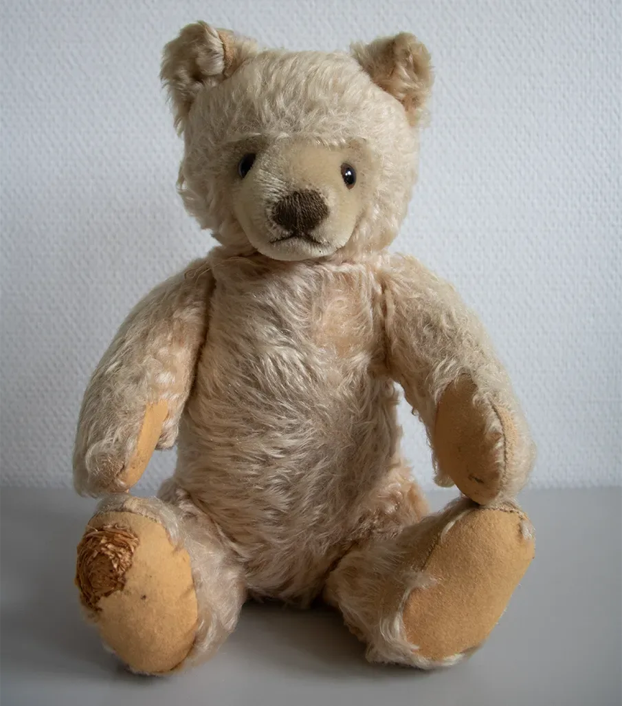 Die Zeiten nach dem Zweiten Weltkrieg waren hart. Dieser Teddybär wurde mit Stroh ausgestopft und aus einfachen Stoffen gefertigt, da es nicht viel Material gab. Kuscheln spendet Trost, auch in schweren Zeiten!