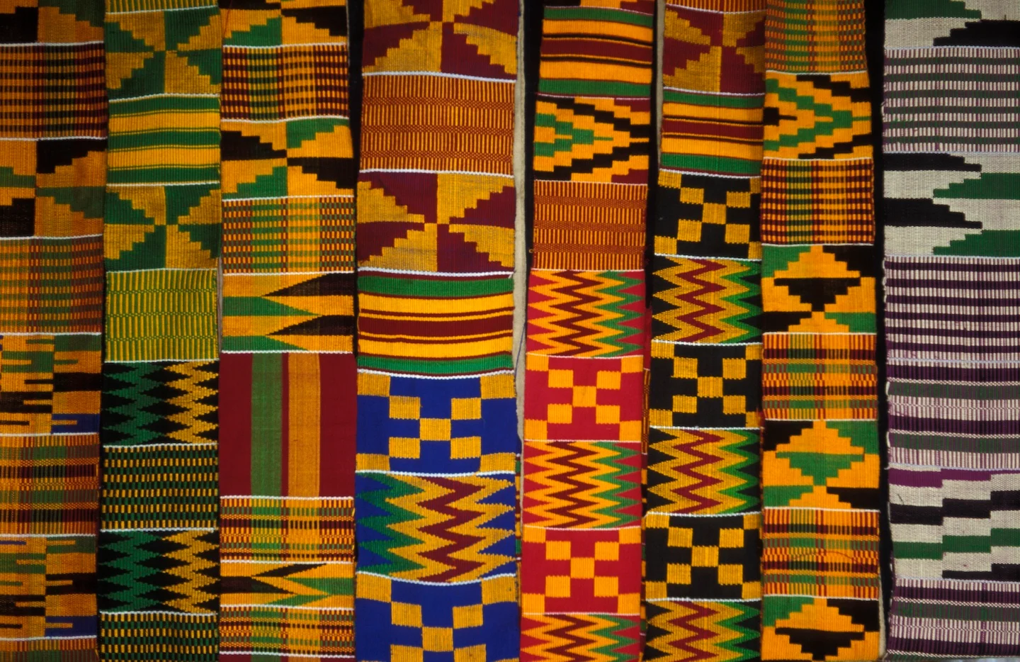 Beim traditionellen Kente-Stoff werden helle geometrische Muster verwendet. Diese Muster bestehen aus senkrechten und waagerechten Streifen und Dreiecken. Die Stoffe werden mit viel Liebe zum Detail gewebt und zusammengenäht. Welche Farbkombinationen siehst du?
