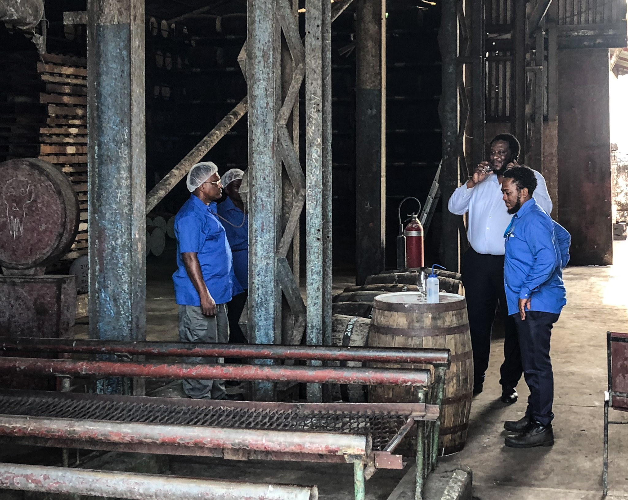 distillery workers gathered around a barrel