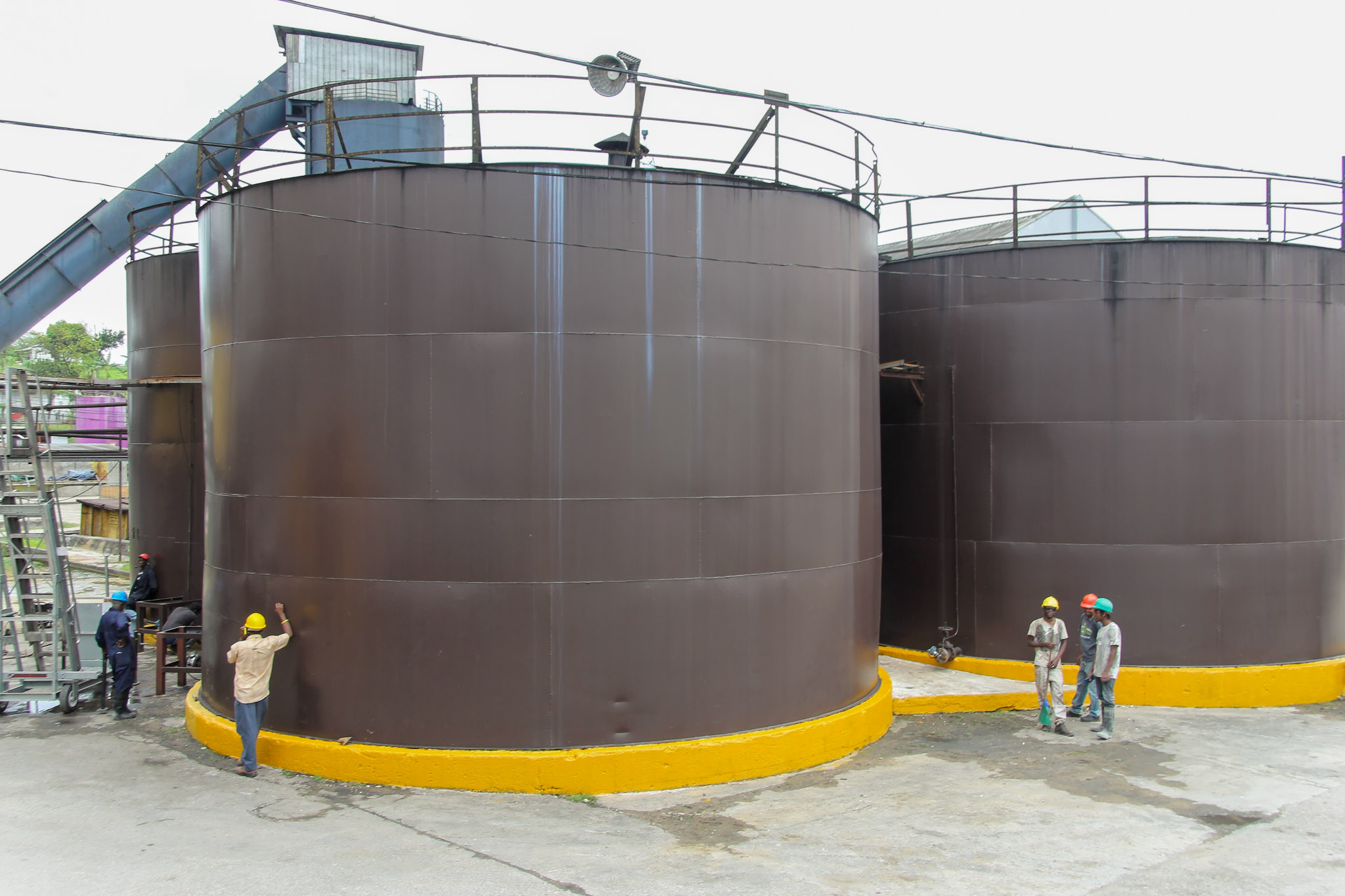 large tanks with small people next to them for scale