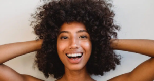 Femme cheveux frisés sourire
