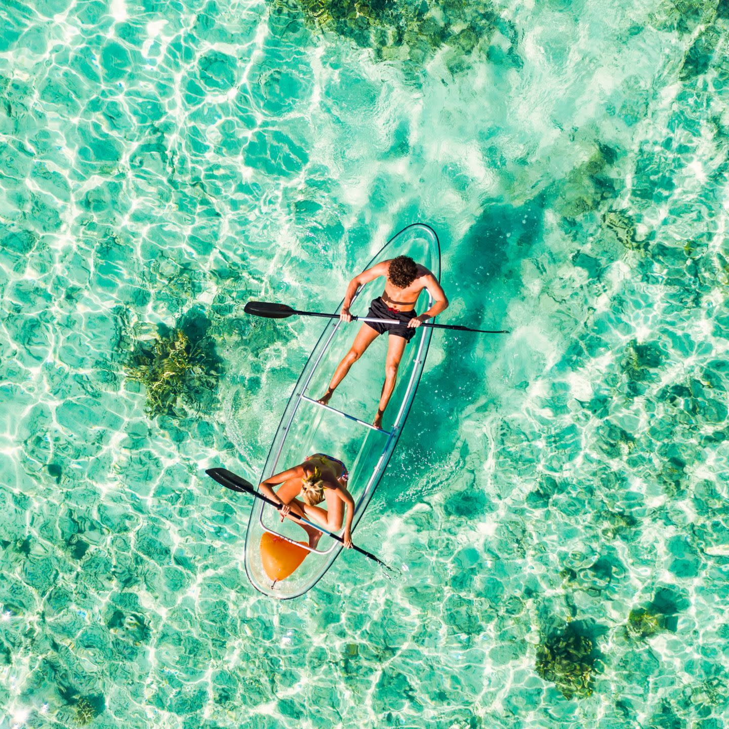 Couple padding on a kayak in the Maldives.