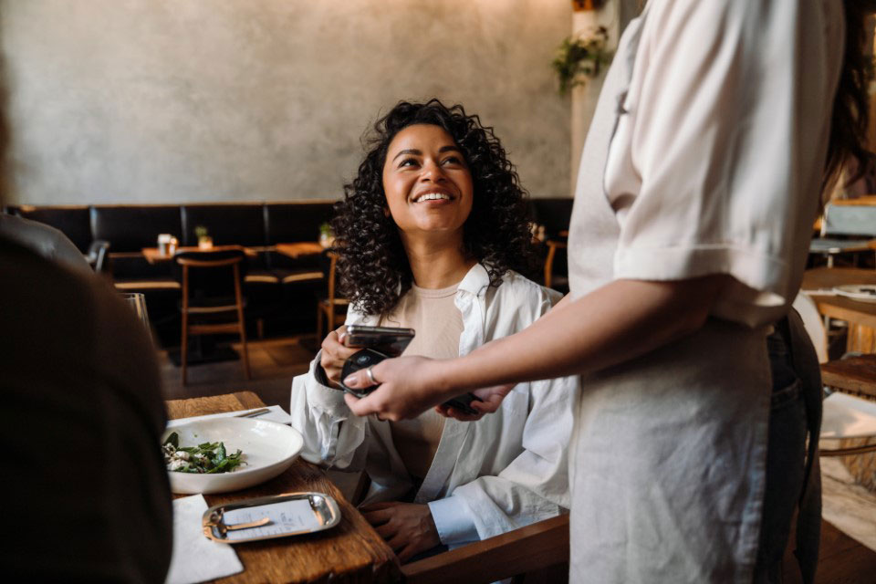 A woman in a cafe paying her bill