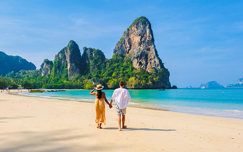 A couple walking along a beach 800x500