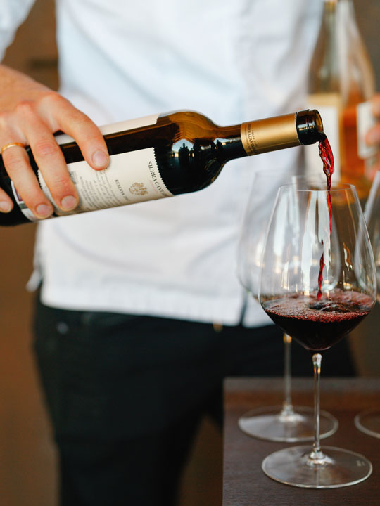 Red wine poured into a wine glass.