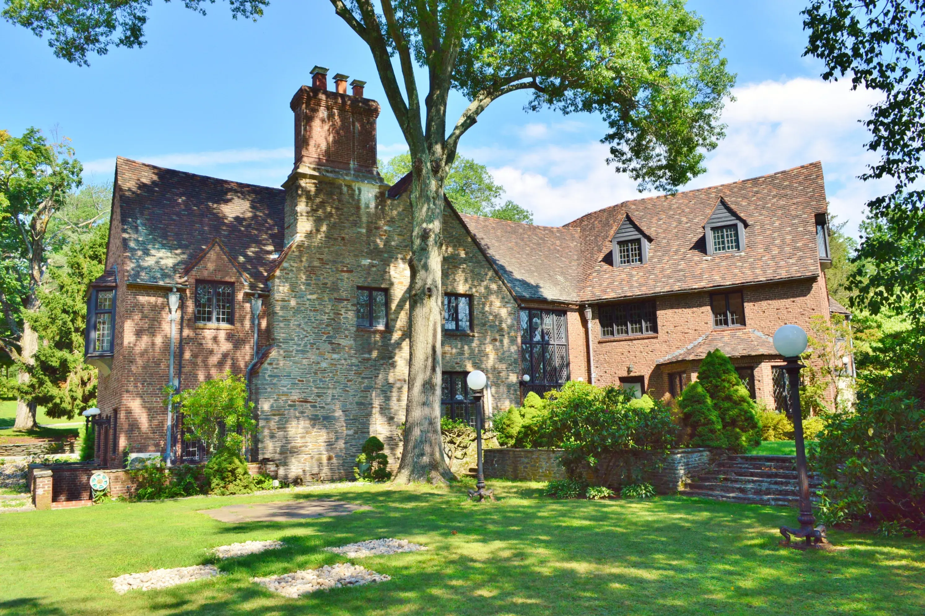 Enchantment awaits down the private winding drive of 64 Orchard Road. Surrounded by a lush wooded landscape and distant rolling hills, yet just minutes from the center of West Hartford, this stunning French Normandy Tudor perched atop 5.3 acres of pastora