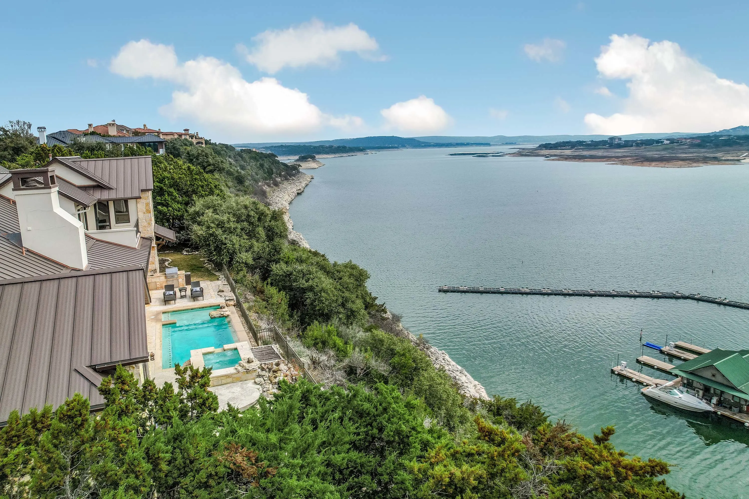 A commanding waterfront residence sits majestically atop one of Lake Travis's most coveted elevations, offering sweeping panoramas across the main water from within the exclusive gated Peninsula at the Hollows.