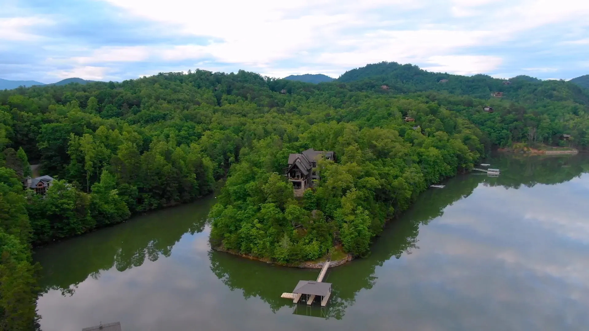 Come home to a luxurious lakefront sanctuary on your very own peninsula surrounded by majestic forest and peaceful waters. Your finely appointed estate at 410 Lakewood Drive blends modern amenities with rustic charm. Rich hardwoods and artisan details per