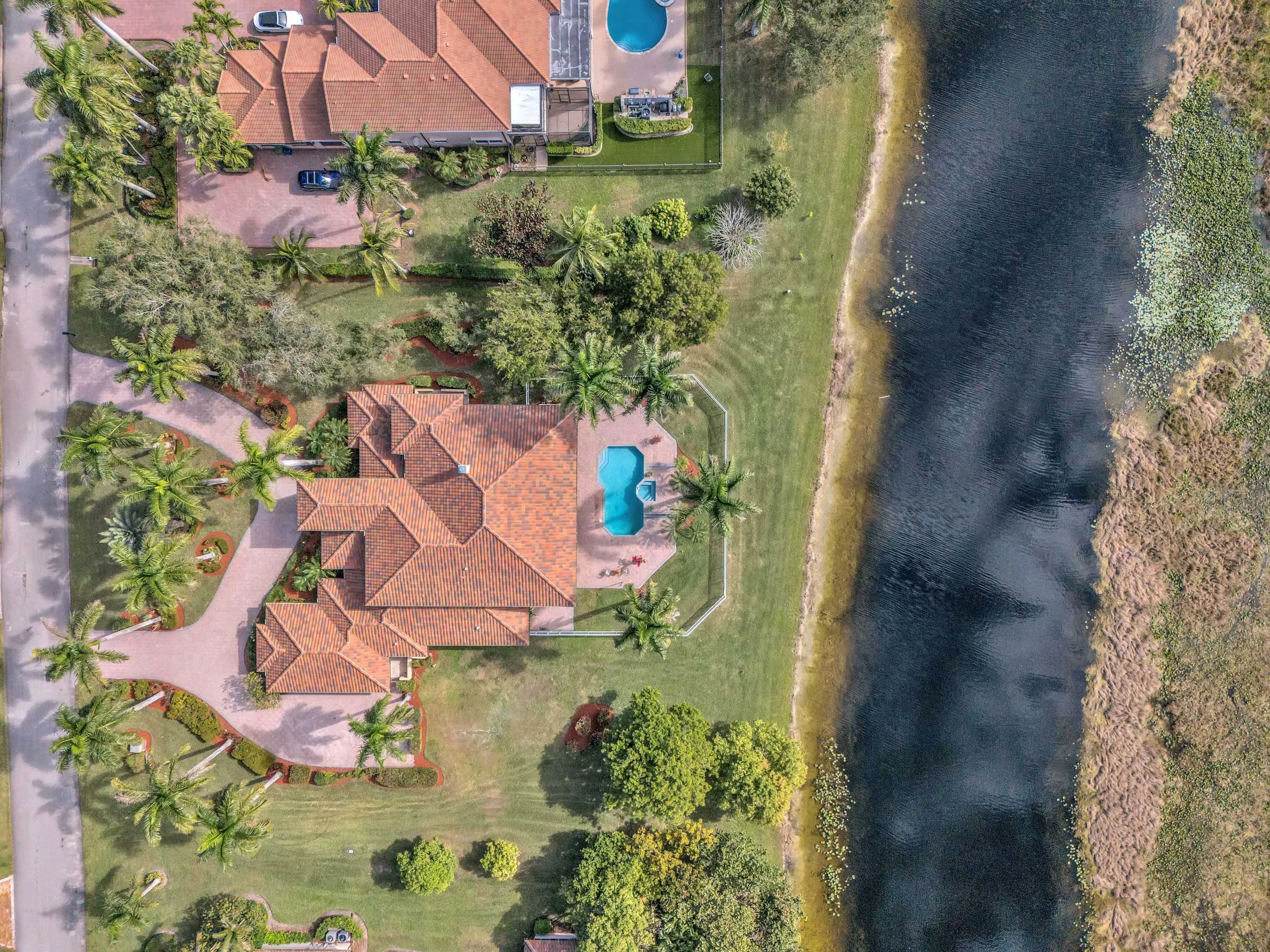 A magnificent lakefront estate awaits within the exclusive gates of Windmill Lake Estates, offering unparalleled luxury on over one acre of pristine grounds in prestigious Weston.
